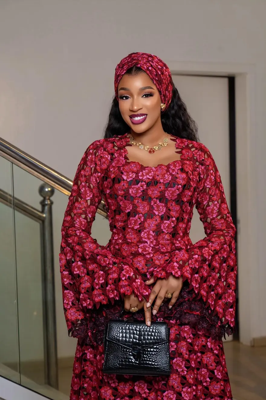 Mouna Seck Kouyaté en guipure framboise, turban coupé dans la même étoffe et parure dorée